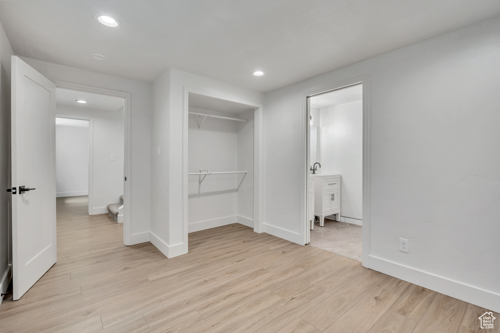 Unfurnished bedroom with light wood finished floors, recessed lighting, a closet, and ensuite bath