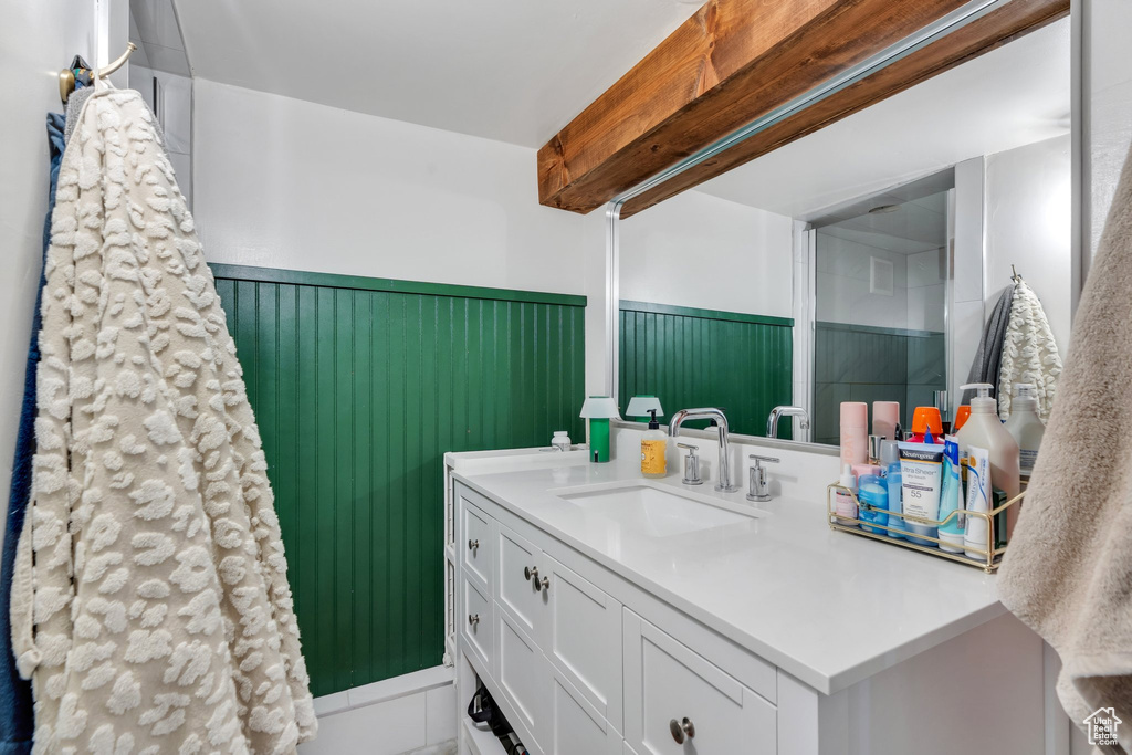 Bathroom with vanity, wainscoting, and beamed ceiling