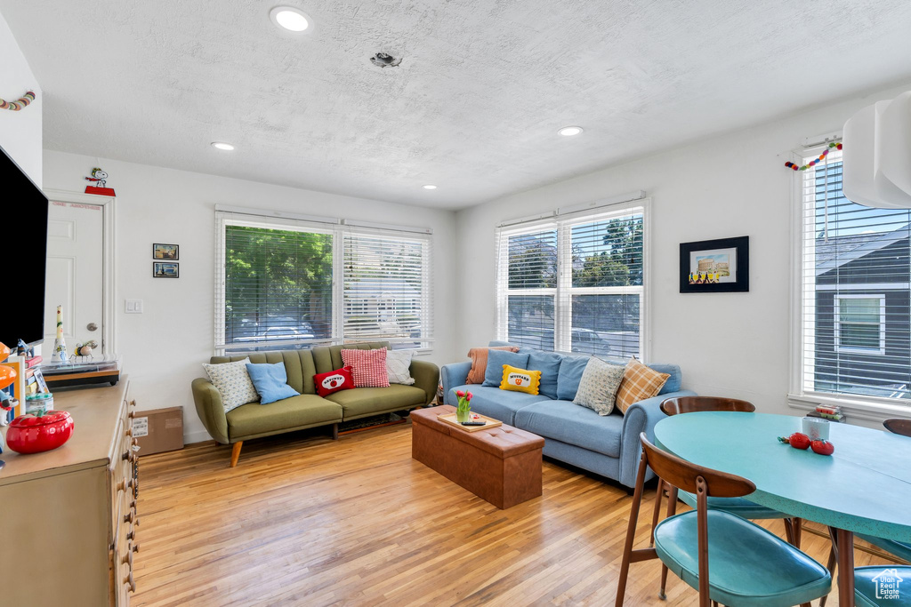 Living room with light wood-style flooring, recessed lighting, and a textured ceiling