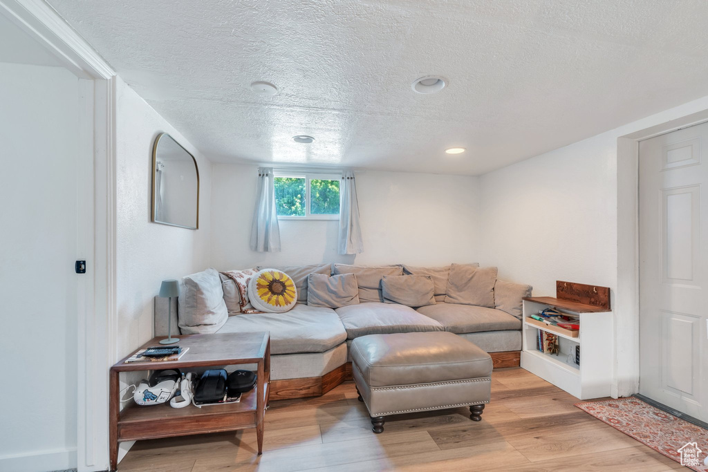 Living area featuring a textured ceiling, light wood-style flooring, and recessed lighting