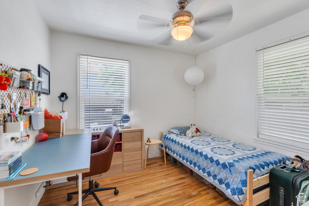 Bedroom featuring light wood-type flooring, a desk, and a ceiling fan
