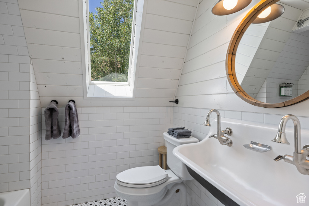 Full bathroom with a bath and tile walls