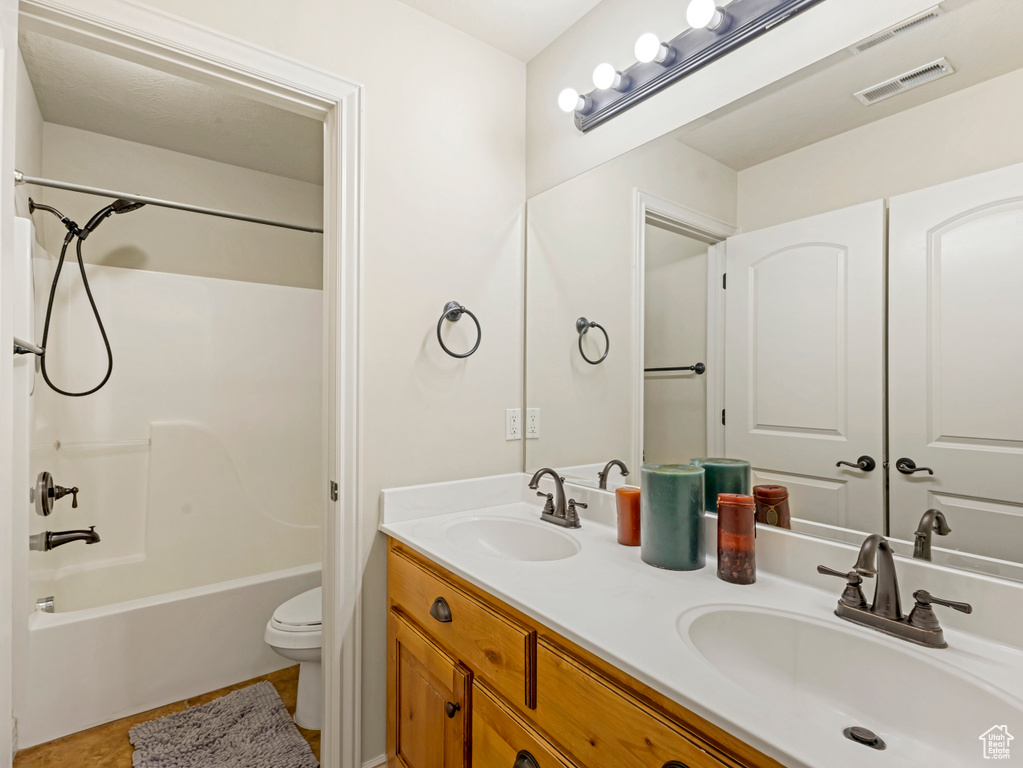 Full bath with double vanity, shower / tub combination, and tile patterned flooring