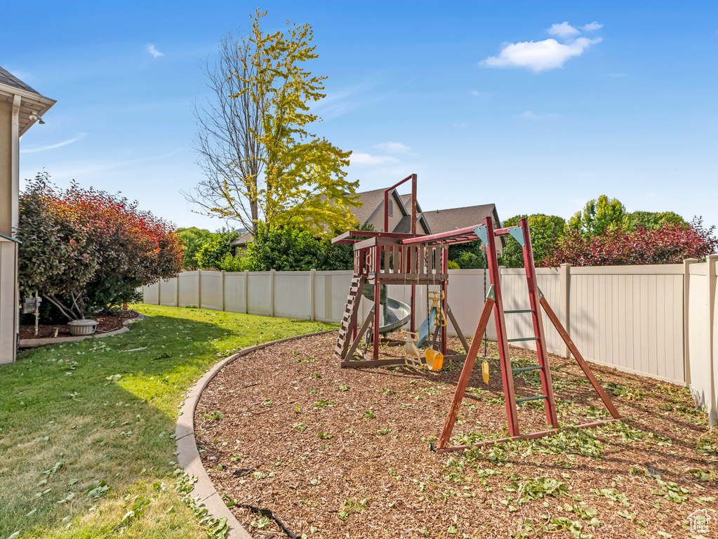View of play area with a fenced backyard