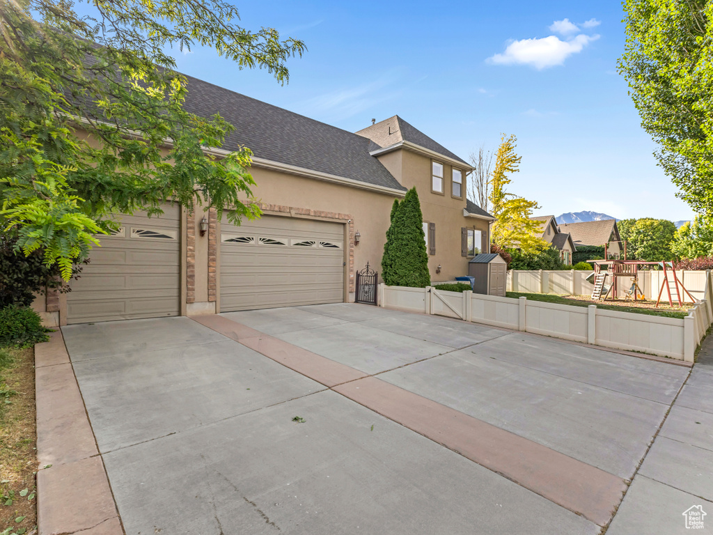 View of front of home featuring concrete driveway, a garage, roof with shingles, and stucco siding