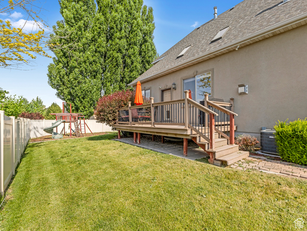 Fenced backyard with a deck and a playground