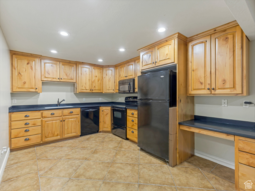 Kitchen with black appliances, dark countertops, recessed lighting, and light tile patterned floors