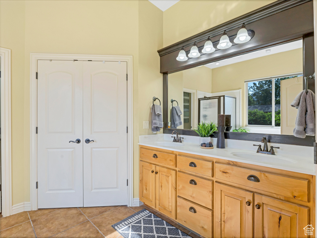 Full bathroom with tile patterned floors, double vanity, and a stall shower