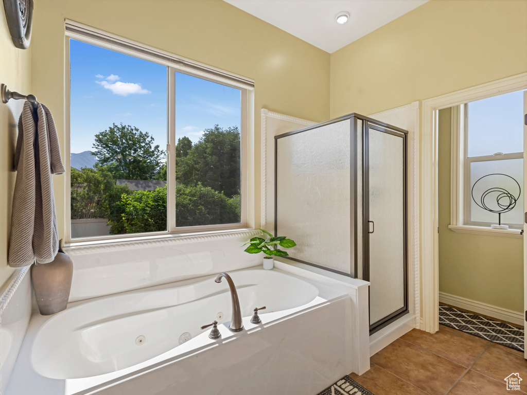 Full bath featuring a shower stall, a tub with jets, and tile patterned flooring