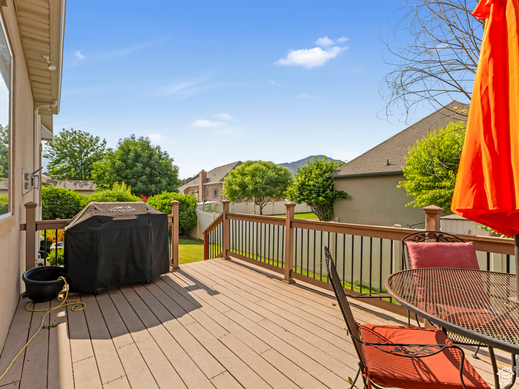 Wooden deck with a mountain view and a grill