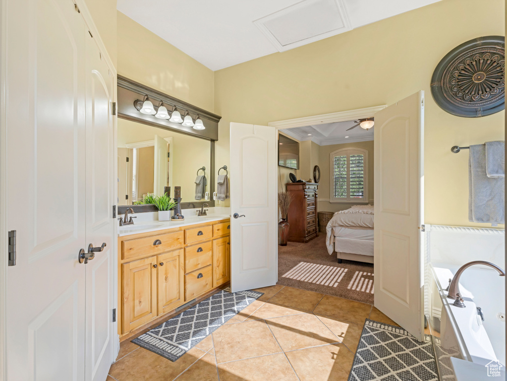 Full bath featuring double vanity, a garden tub, tile patterned flooring, ensuite bath, and ornamental molding