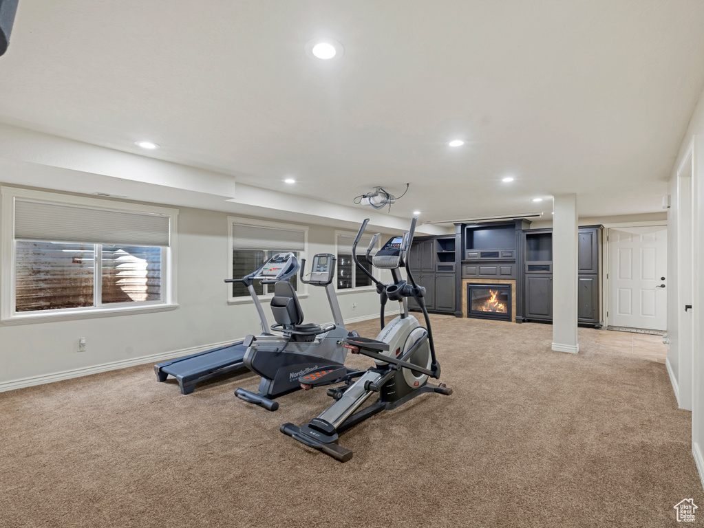 Exercise room featuring carpet floors, a glass covered fireplace, and recessed lighting