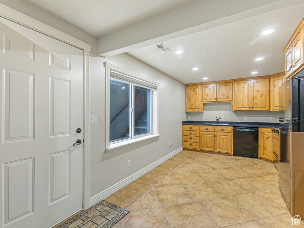 Kitchen featuring black dishwasher, dark countertops, recessed lighting, and light tile patterned floors
