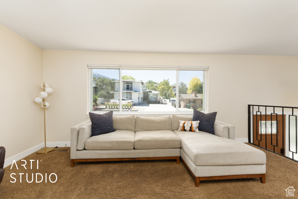 Carpeted living area featuring baseboards
