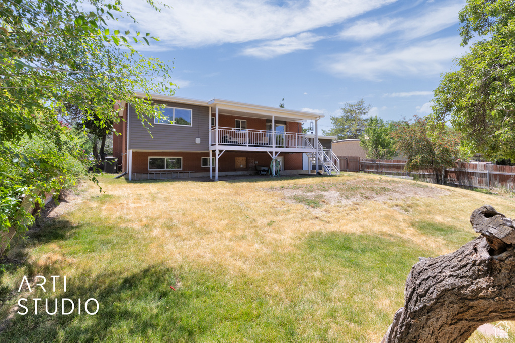 Back of house featuring stairway, a fenced backyard, and a deck