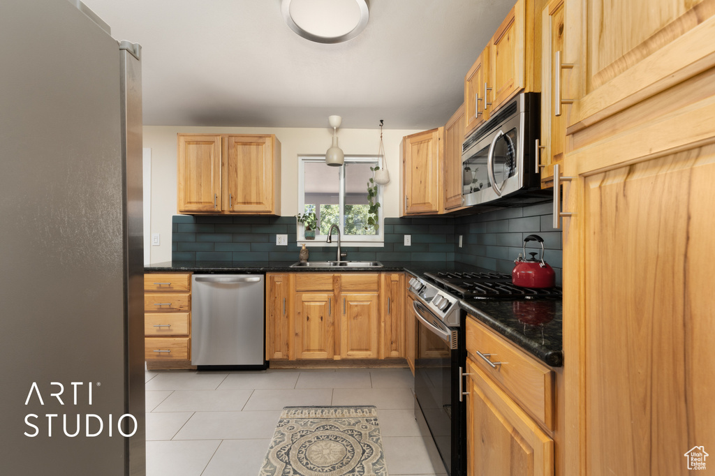 Kitchen with appliances with stainless steel finishes, backsplash, and light tile patterned flooring