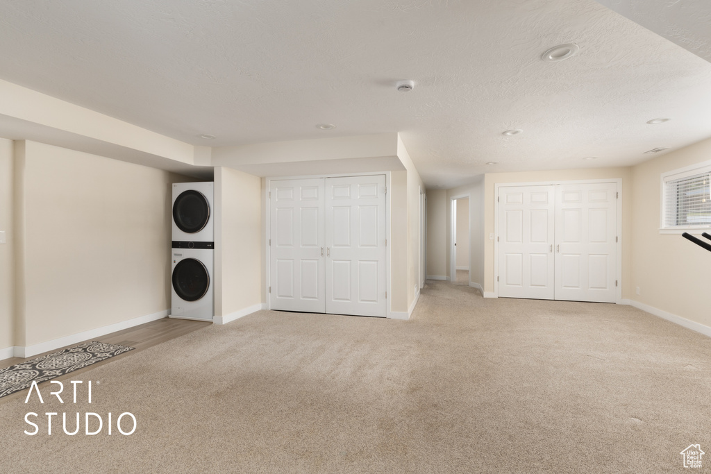 Unfurnished bedroom featuring stacked washer / dryer, carpet floors, and recessed lighting