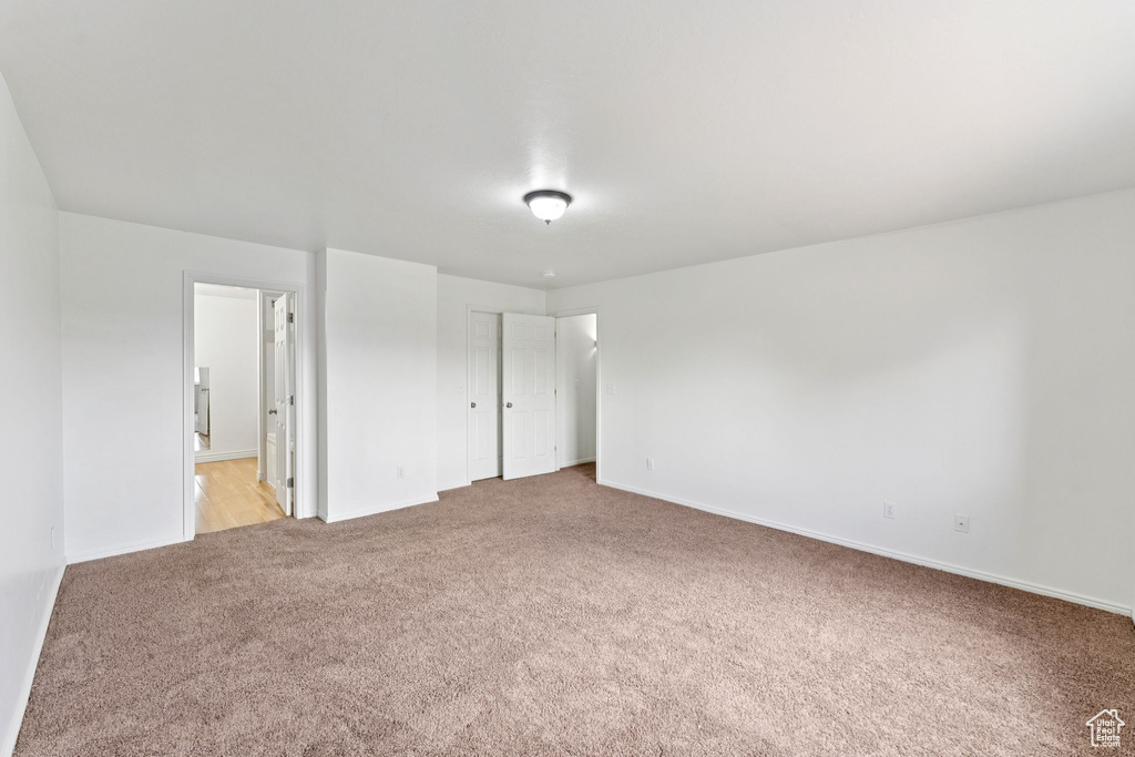 Unfurnished bedroom with light colored carpet and ensuite bath