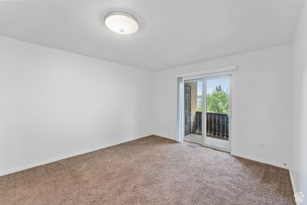Carpeted empty room featuring baseboards