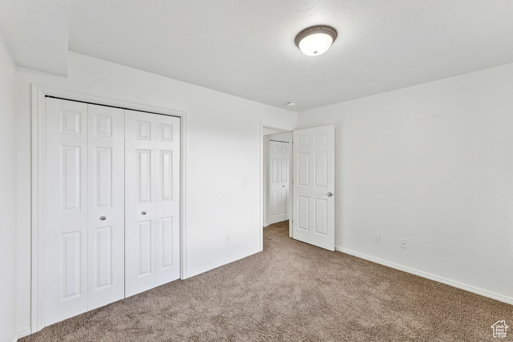 Unfurnished bedroom featuring carpet floors and a closet