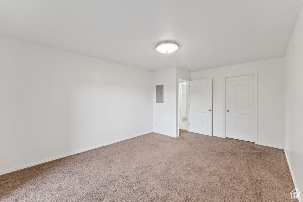 Unfurnished bedroom with carpet flooring and electric panel