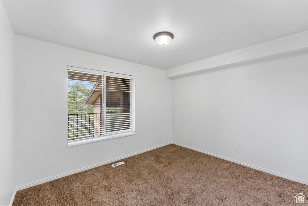Carpeted empty room featuring baseboards