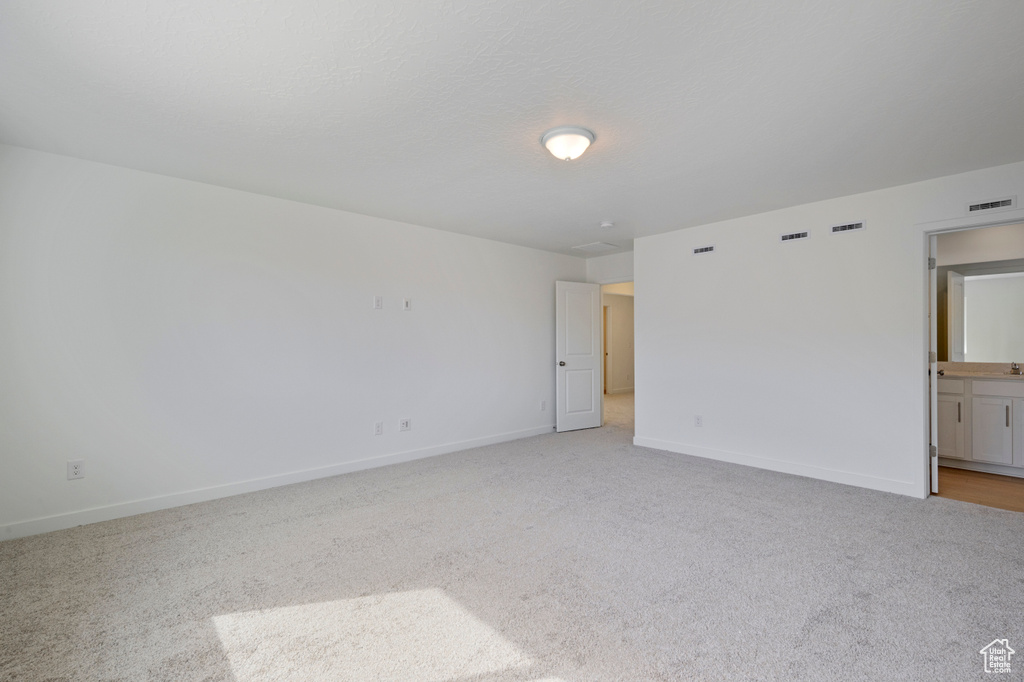 Empty room featuring light carpet and baseboards
