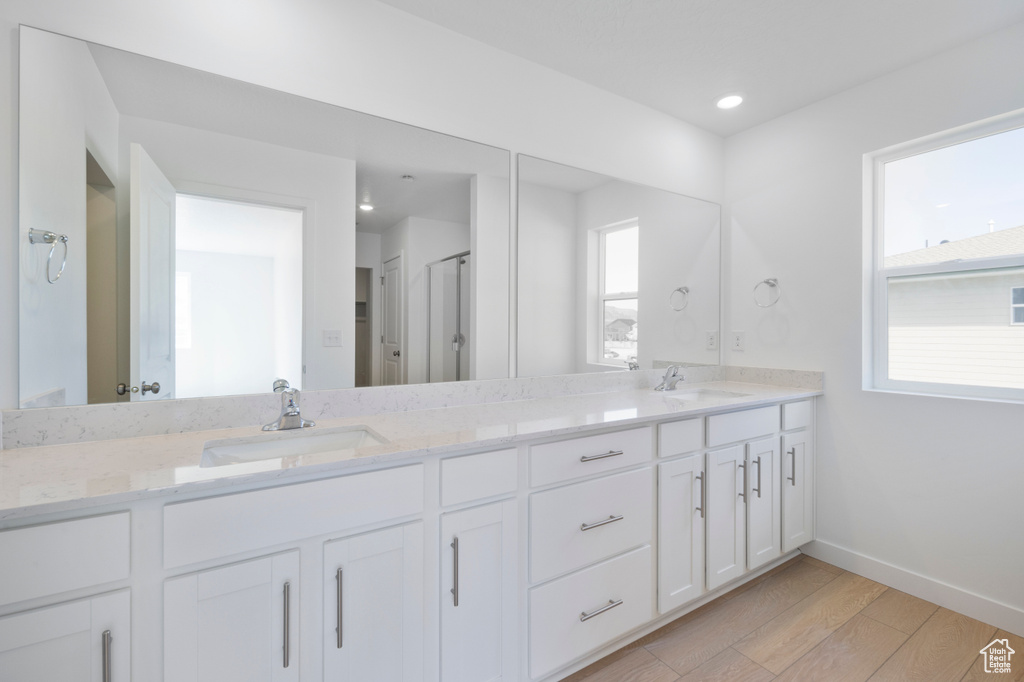 Full bathroom featuring double vanity, wood finished floors, recessed lighting, and a shower with shower door