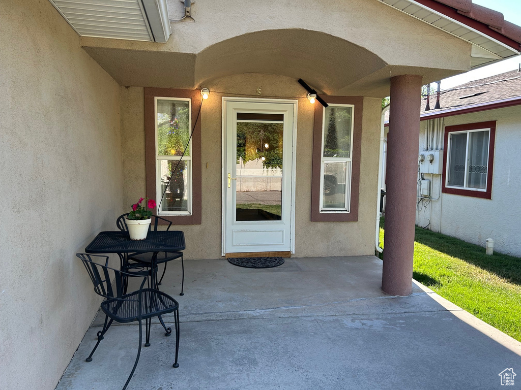 Property entrance featuring stucco siding and a patio area