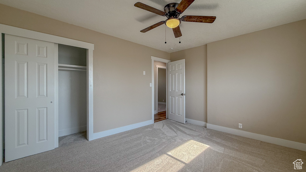 Unfurnished bedroom with light carpet, a closet, and ceiling fan