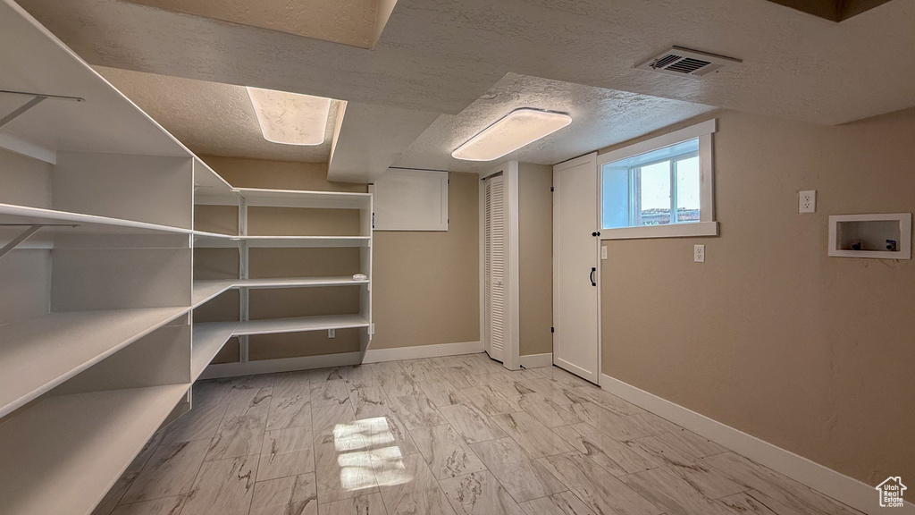 Below grade area featuring baseboards and a textured ceiling
