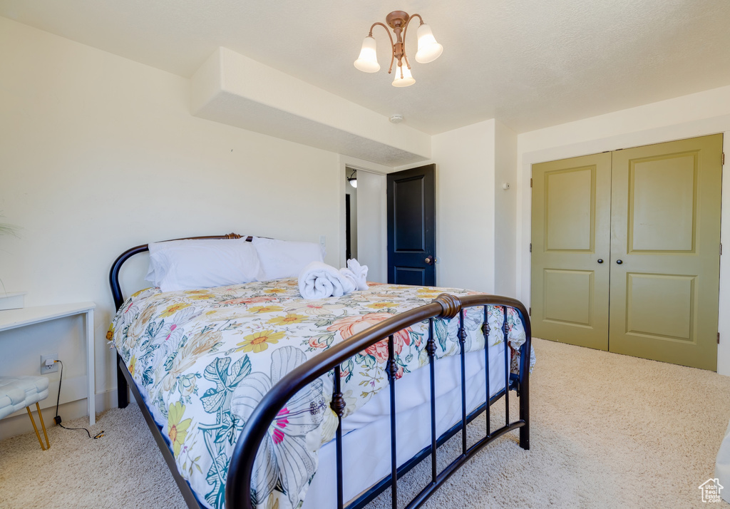 Carpeted bedroom with a closet and baseboards