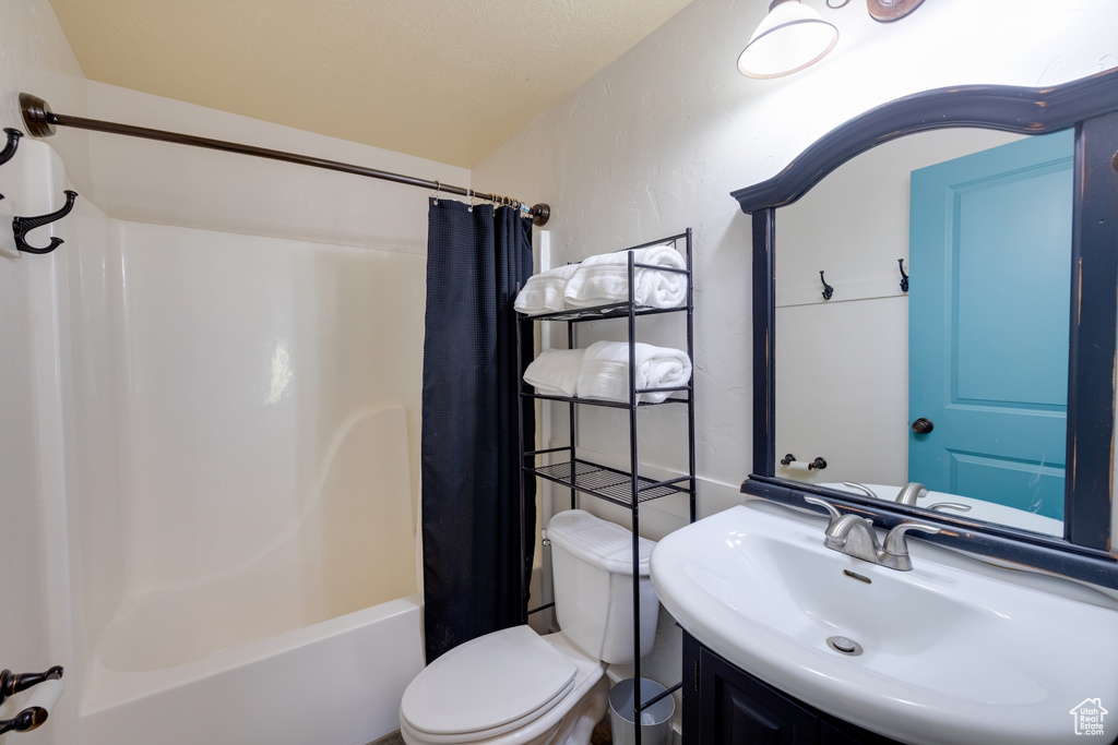 Bathroom featuring vanity and shower / bath combination with curtain