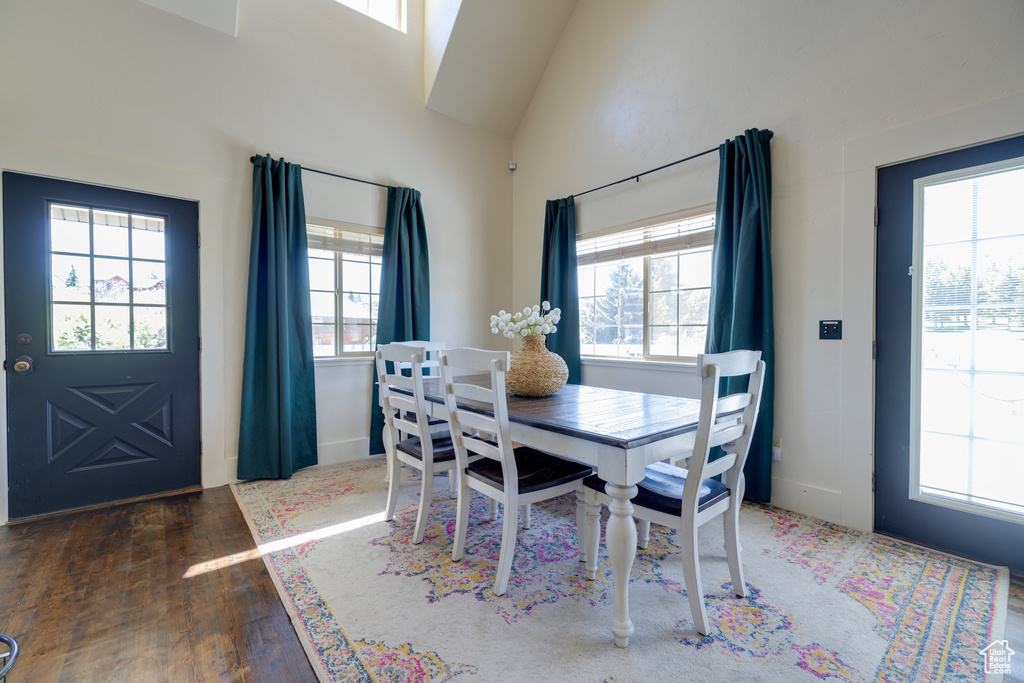Dining room featuring plenty of natural light, hardwood / wood-style floors, and high vaulted ceiling