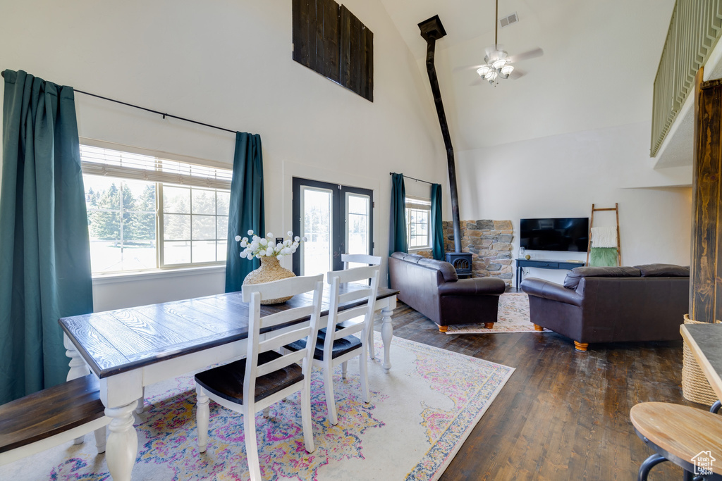 Dining space with high vaulted ceiling, dark wood-style floors, healthy amount of natural light, and ceiling fan