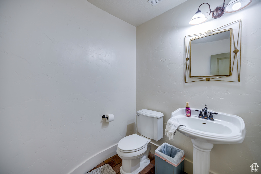 Half bath featuring toilet and wood finished floors