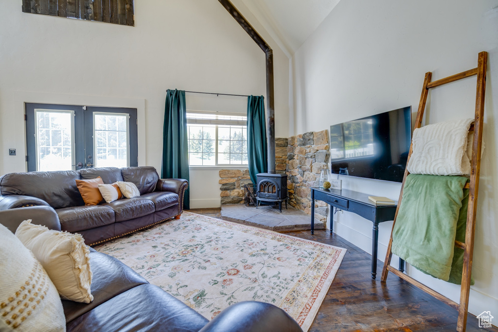 Living room featuring a wood stove, high vaulted ceiling, wood finished floors, and french doors