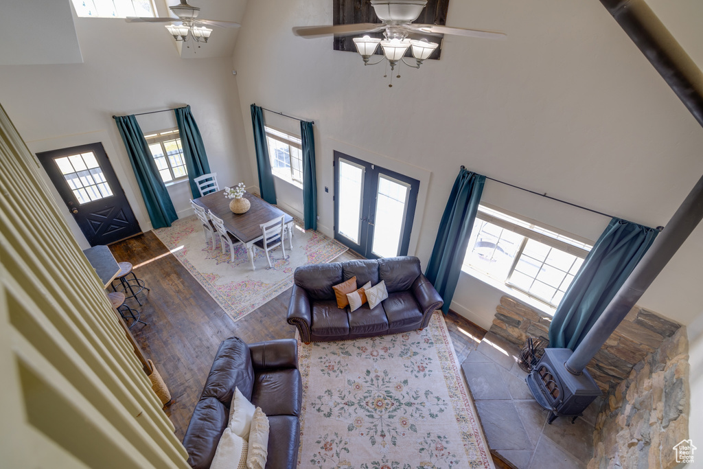 Living room with ceiling fan, a high ceiling, wood finished floors, and french doors