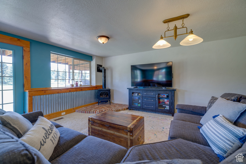 Living room with a wood stove, healthy amount of natural light, and a textured ceiling