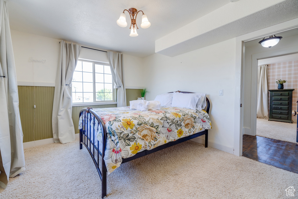 Carpeted bedroom featuring baseboards and wainscoting