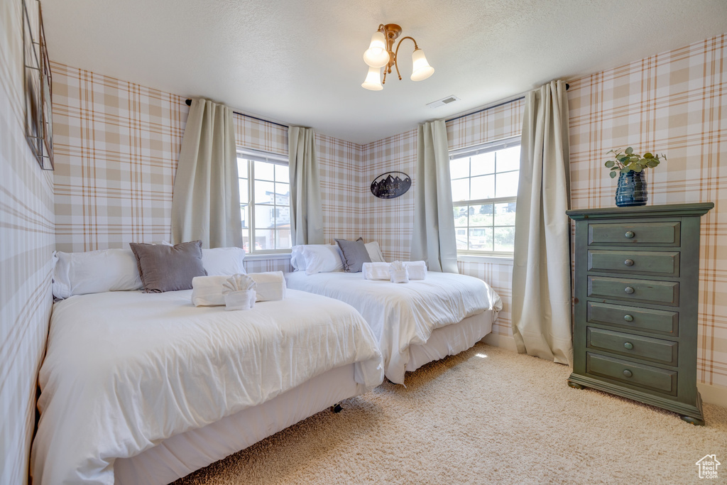 Bedroom with multiple windows, carpet, and wallpapered walls