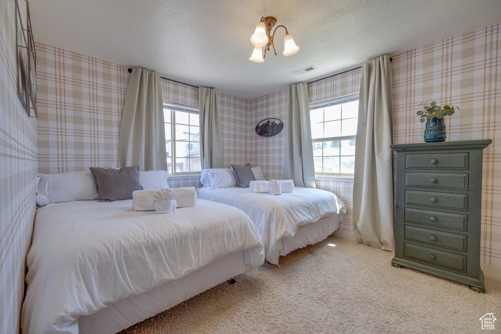 Bedroom with multiple windows, carpet, and wallpapered walls