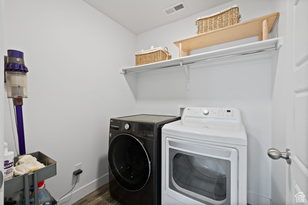 Laundry room with independent washer and dryer and dark wood-style floors