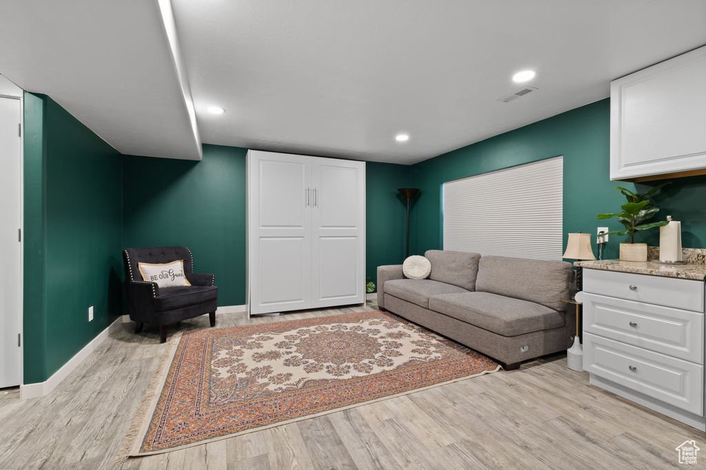 Living area with light wood-style flooring and recessed lighting