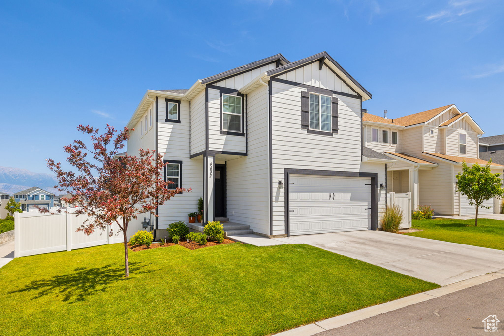 View of front of home with board and batten siding, concrete driveway, and a garage