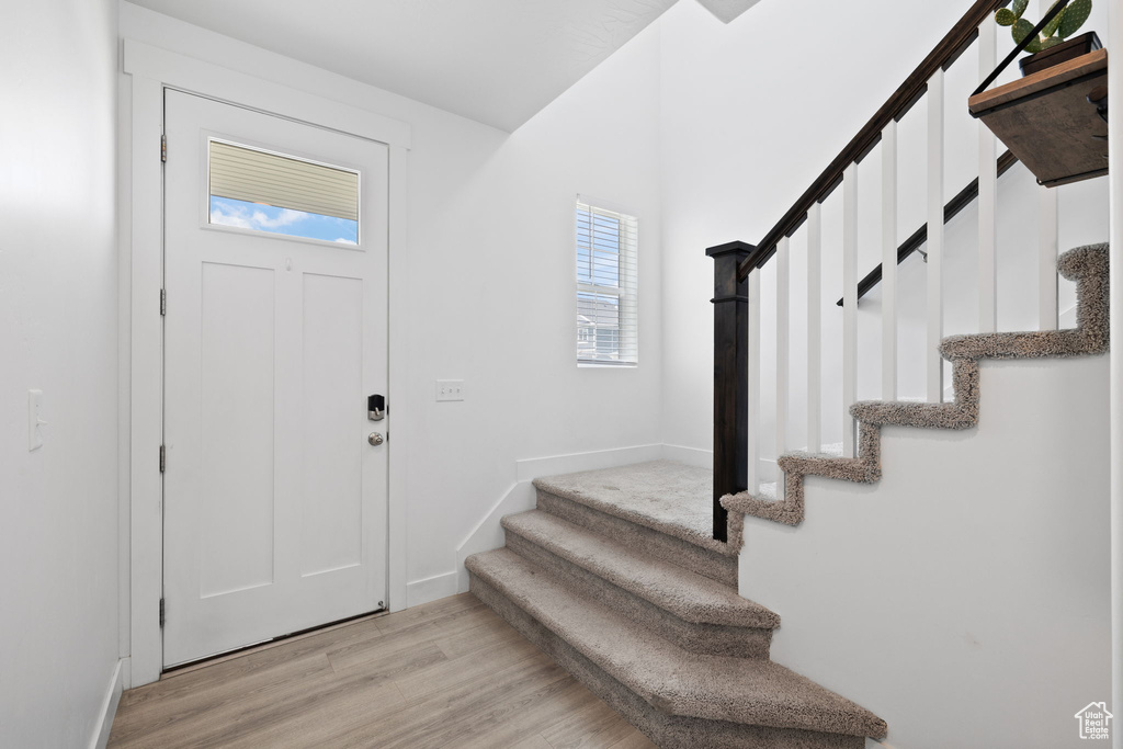 Foyer featuring stairs and light wood-style floors