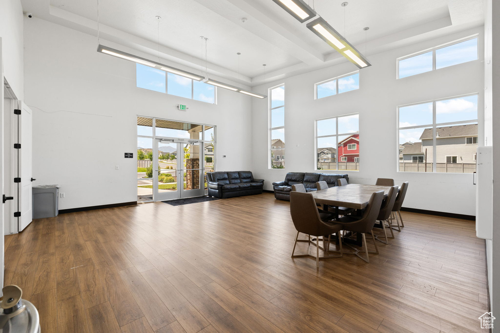 Dining room featuring a tray ceiling, a towering ceiling, and wood finished floors