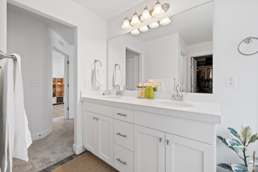Bathroom with double vanity and a walk in closet