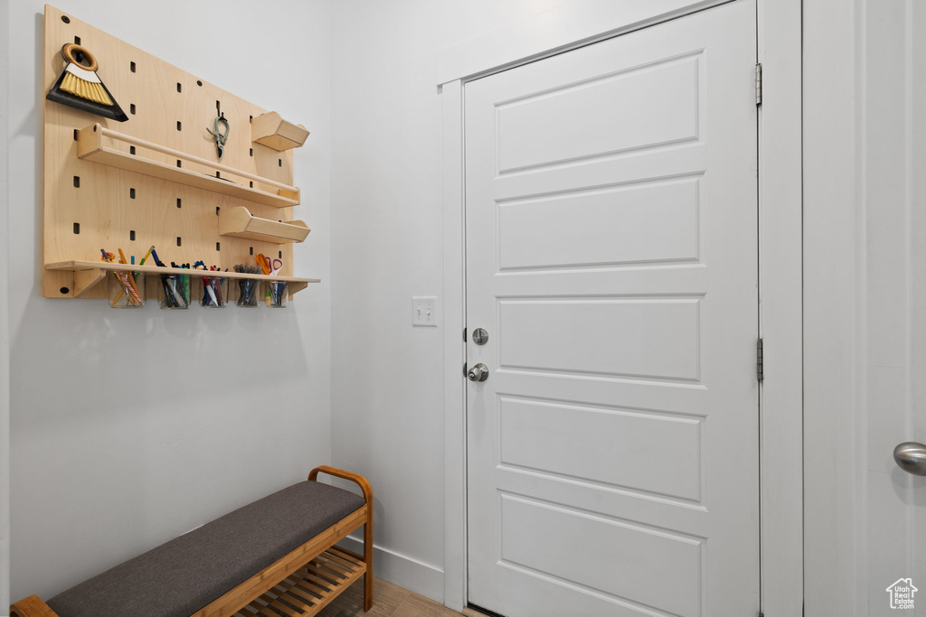 Doorway featuring baseboards and wood finished floors