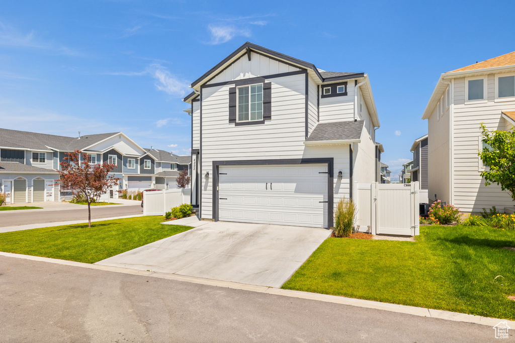 View of front of home with a residential view, board and batten siding, a gate, concrete driveway, and a garage
